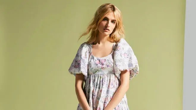 model on green background posing floral dress