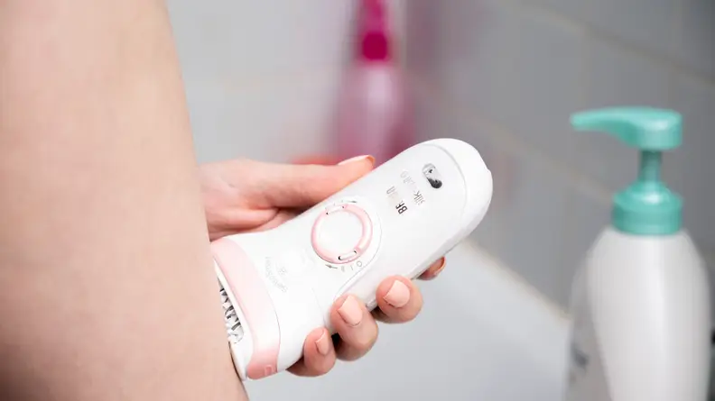 A person using the Braun Silk-Epil 9 on their leg.