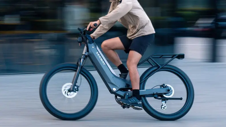 A person in profile rides a Segway Xafari bike.