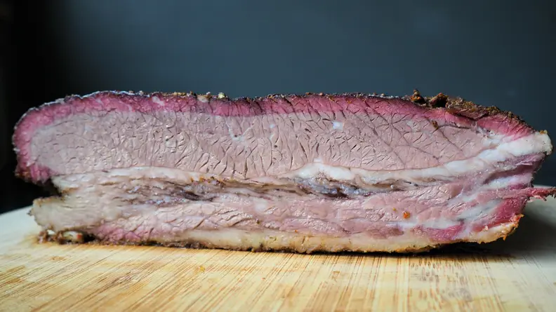A brisket sliced in half showing its smoke ring detail.