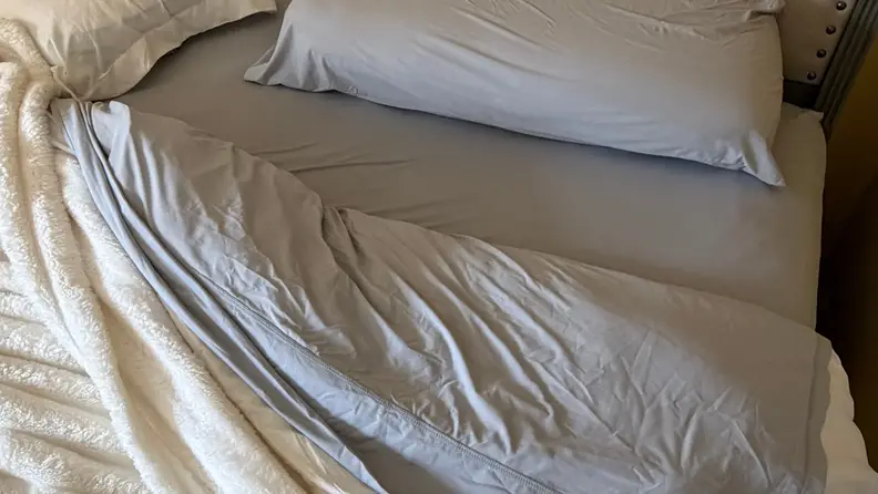A bed with gray sheets