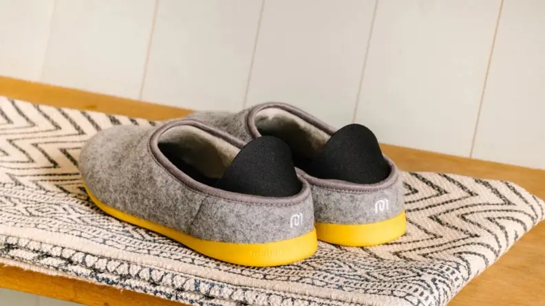 The backside of a pair of Mahabis Classic Men's Slippers, showing off yellow soles and logo.