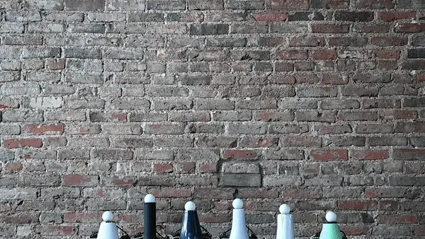 The barrel of several hair dryers facing upward with ping pong balls hovering over them.