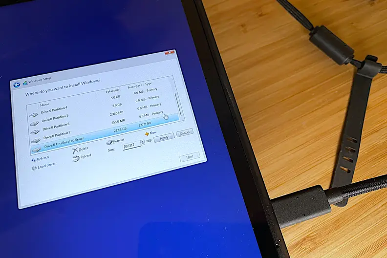 A black handheld gaming console showing part of the Windows 11 OS installation process