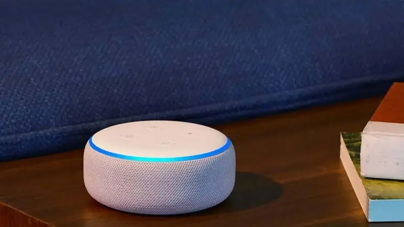An Amazon Echo Dot sits on a table.