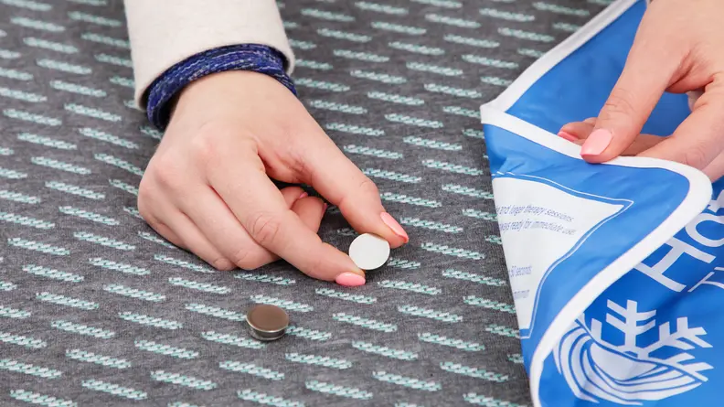 A person putting a heat sensor onto the Tuft & Needle Mint hybrid mattress.