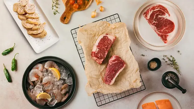 A collection of meats and shellfish from Crowd Cow on a surface.