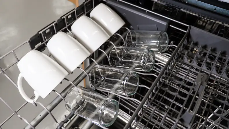 The third rack of the KitchenAid KDTM404KPS dishwasher with mugs and glasses on one side of it.