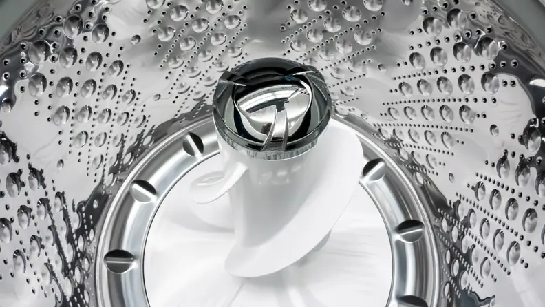 A shot of the interior of the LG WT7305CV Top-loading Washing Machine's drum, with a focus on its central pole agitator.