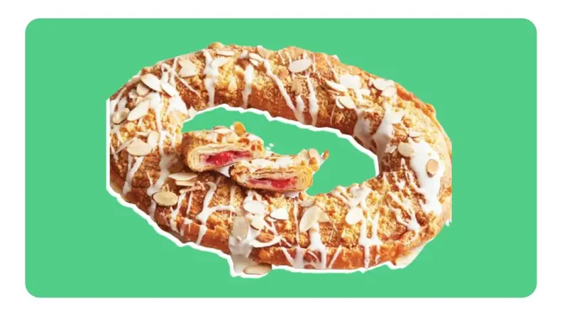 A glazed Danish Kringle pastry in front of green background.