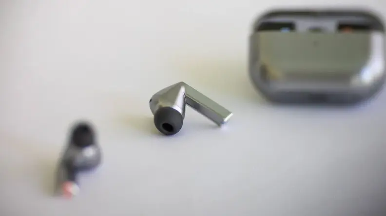 The Samsung Galaxy Buds3 Pro earbuds in front of its charging case.