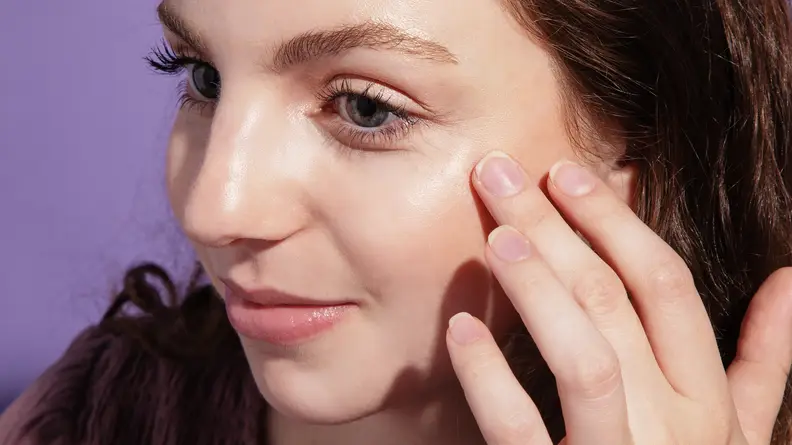 A woman showing off applied Saie Beauty.