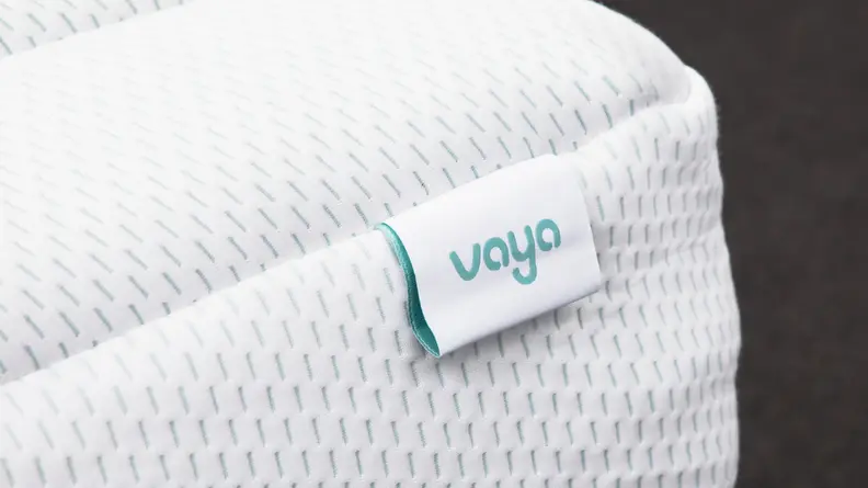 Close-up shot of the Vaya logo printed on a tag located on the corner of the mattress.