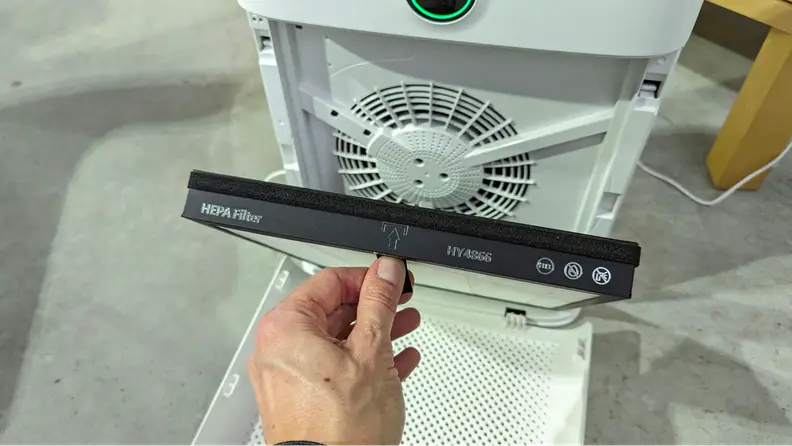A hand opens the interior of the Morento Air Purifier to access its HEPA filter.