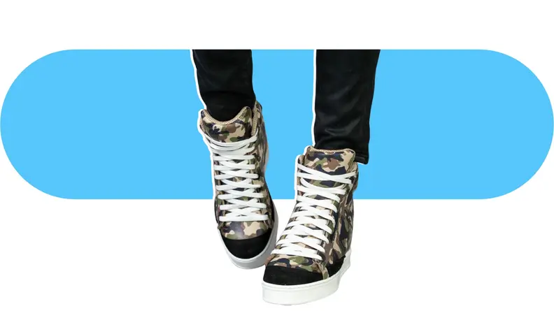 Close-up of a model wearing camouflage print wedge sneakers.