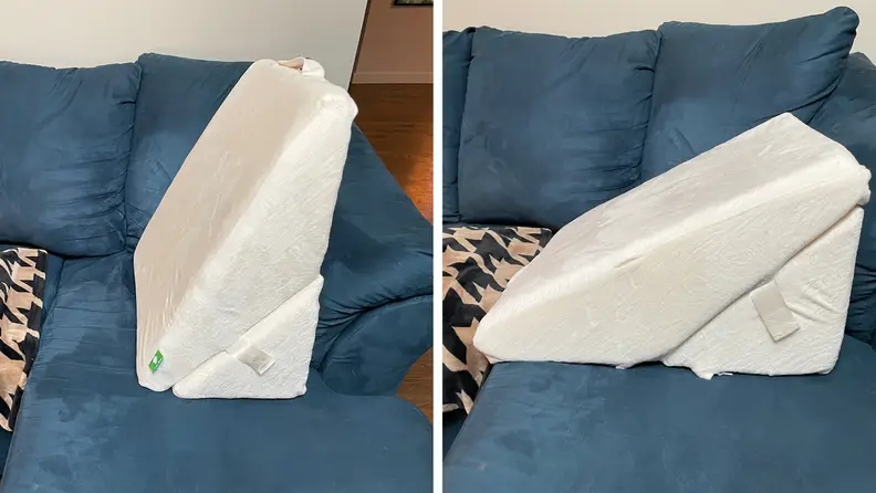 A Cushy Form Wedge Triangle Pillow upright and horizontal on blue suede couch.