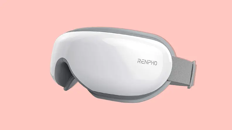 A white Renpho Eyeris 1 eye massager turned slightly on an angle on a pink background.