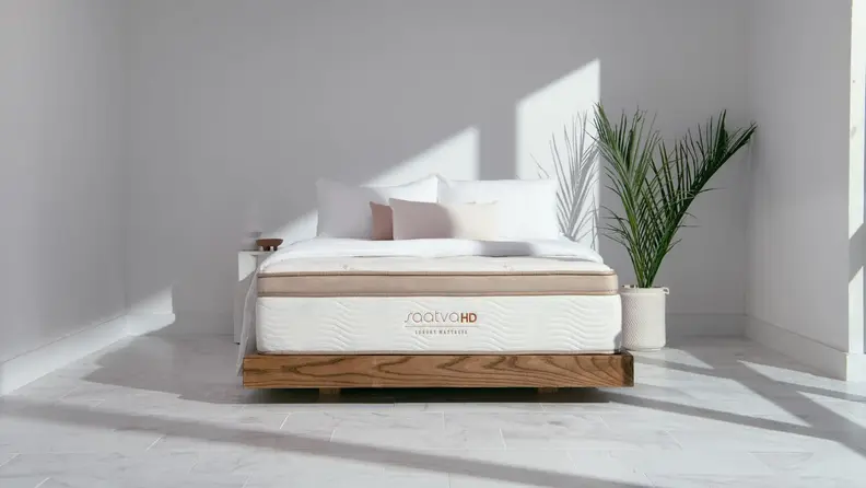 A Saatva mattress on a bed frame.