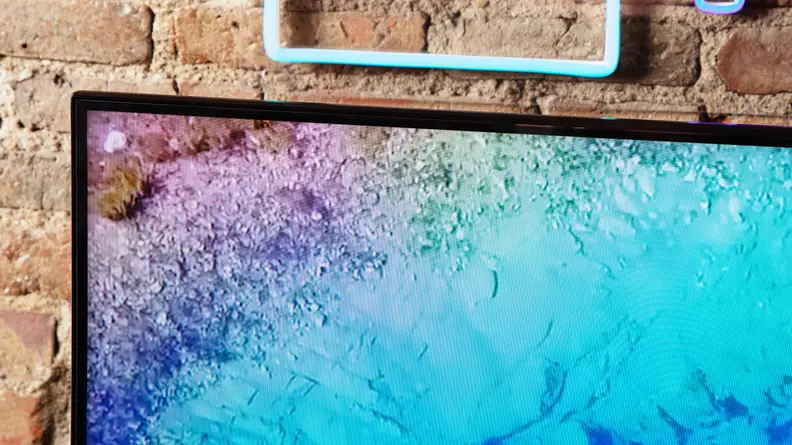 A close-up of the Hisense U8N's display with its top and side bezel centered in front of a brick wall