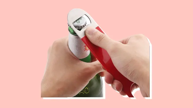 Hand opening a bottle with a bottle opener