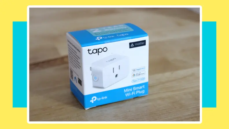 Box packaging for the Tapo Smart Plug Mini sitting on top of wooden surface.