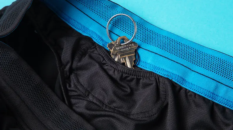 A pair of keys is visible in an interior pocket of the Janji running shorts.