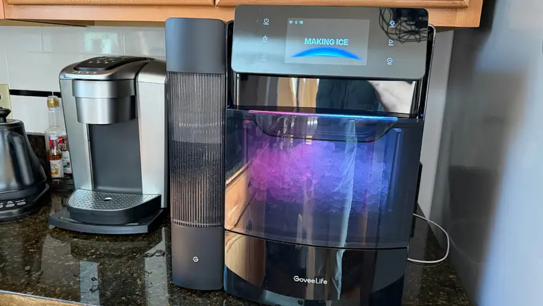 The GoveeLife ice maker on a kitchen counter with purple RGB lighting illuminating the internal ice compartment.