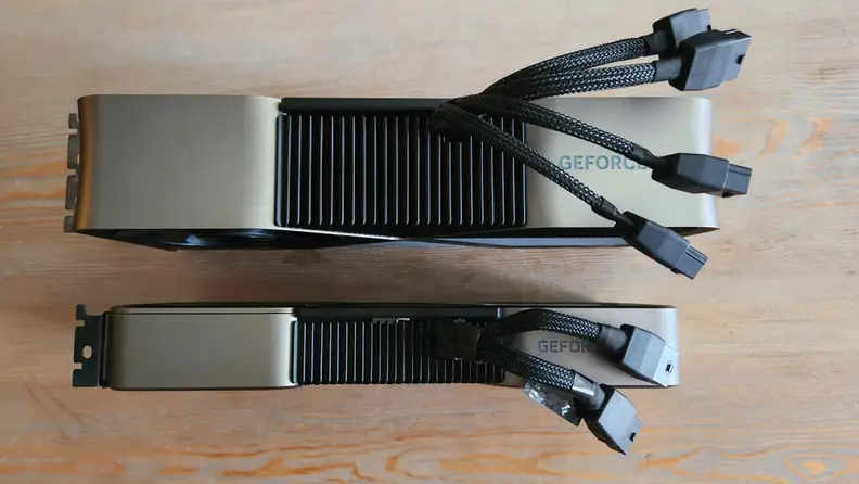 Two graphics cards standing upright side by side with cables coming out of the top.