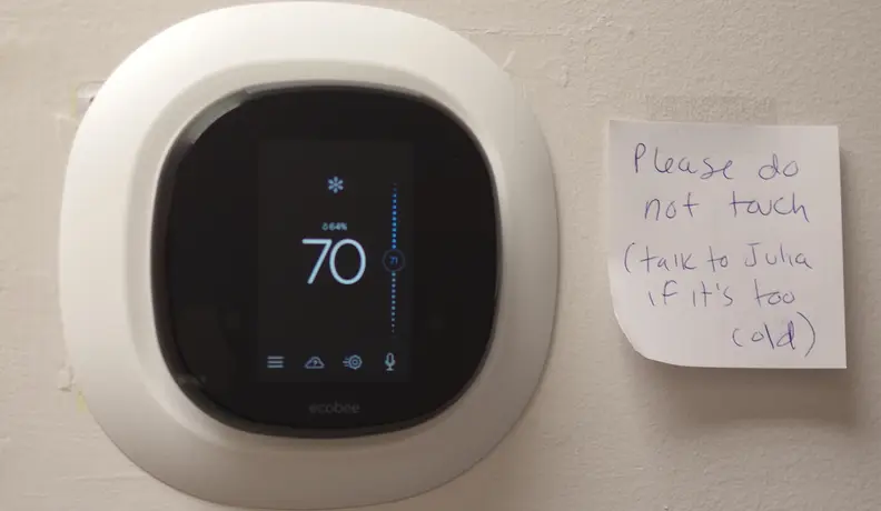 Smart thermostat with a sassy note next to it