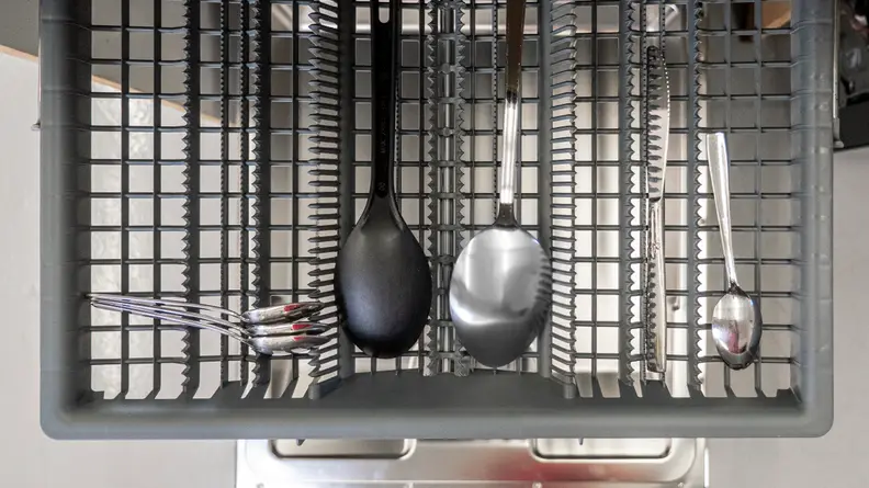 A top-down shot of the third rack, which is loaded with a few ladles and pieces of silverware.