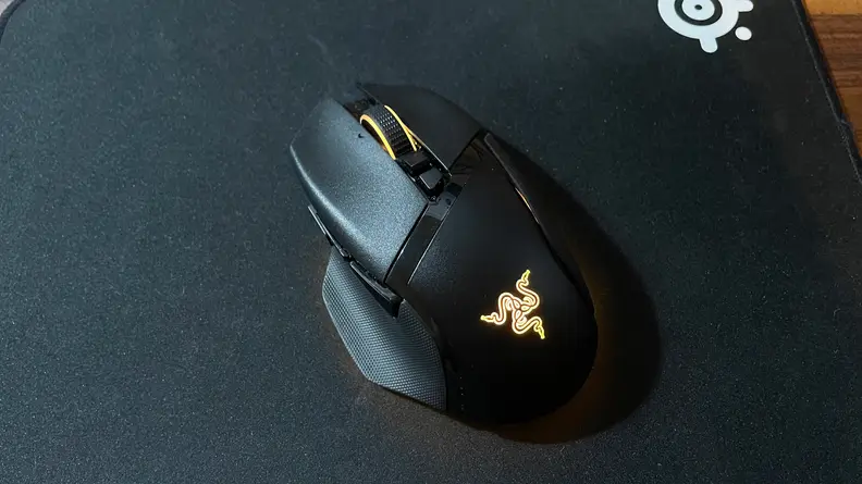 The Razer Basilisk V3 Pro sitting by itself with a yellow LED light on.
