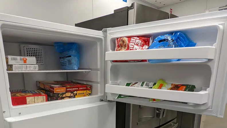 A close-up of the freezer compartment and its door bins, all stocked with food.