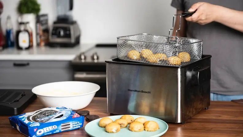 The Hamilton Beach Professional Grade Deep Fryer filled with fried food sits on a kitchen counter.
