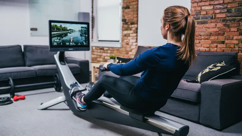 Woman working out on Hydrow rowing machine.