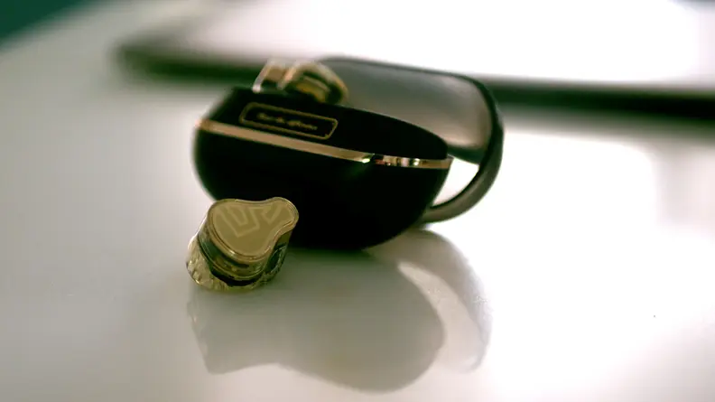 A single earbud next to its case