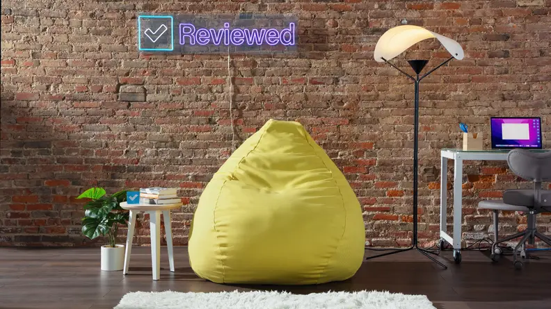 Floyd furniture products including the side table, Y-Lamp and Squishy Chair in front of a brick wall indoors.