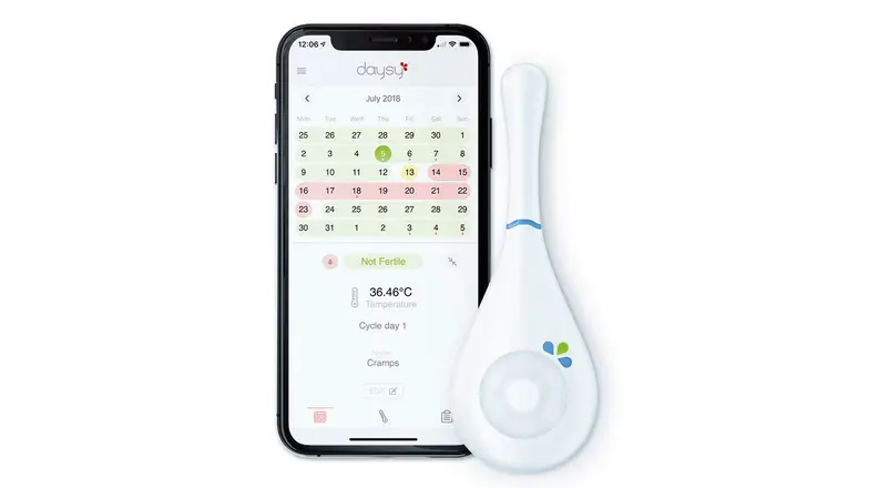 Daysy thermometer next to phone with DaysyView app on screen
