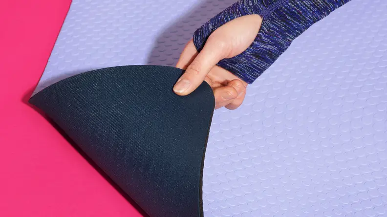 Person lifting up the corner of the lululemon 5mm Workout Mat to display the foam.