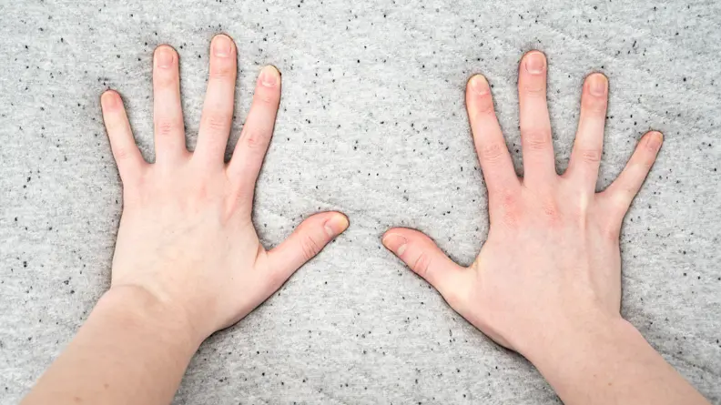 a woman's hands press into a foam mattress