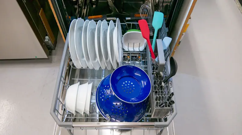 Plates, colander, bowls and kitchen utensils sitting on lower rack of LG LDTH7972S dishwasher.
