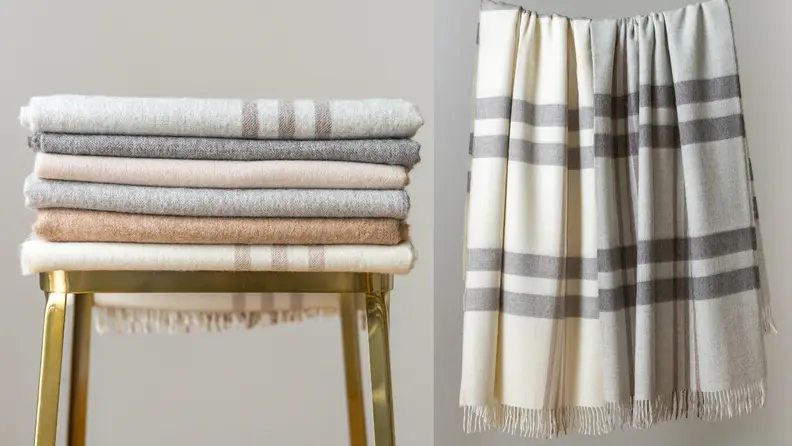 Left: Stack of folded blankets on stool; Right: Two wool blankets hanging up