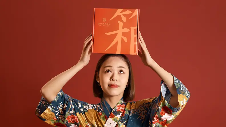 Woman holding box of Bokksu on her head