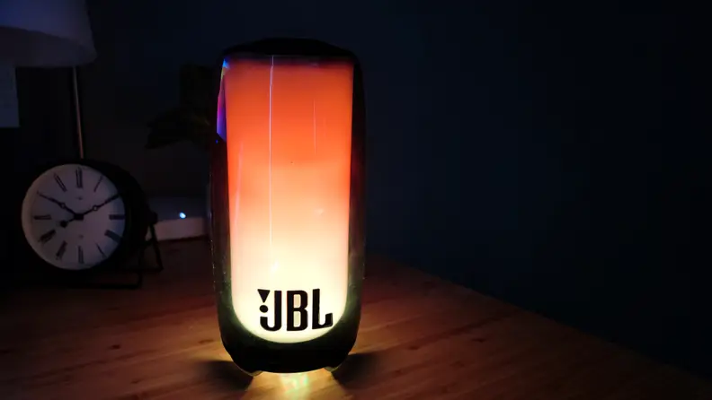 The JBL Pulse 5 shown playing a lava lamp effect in a dark room.