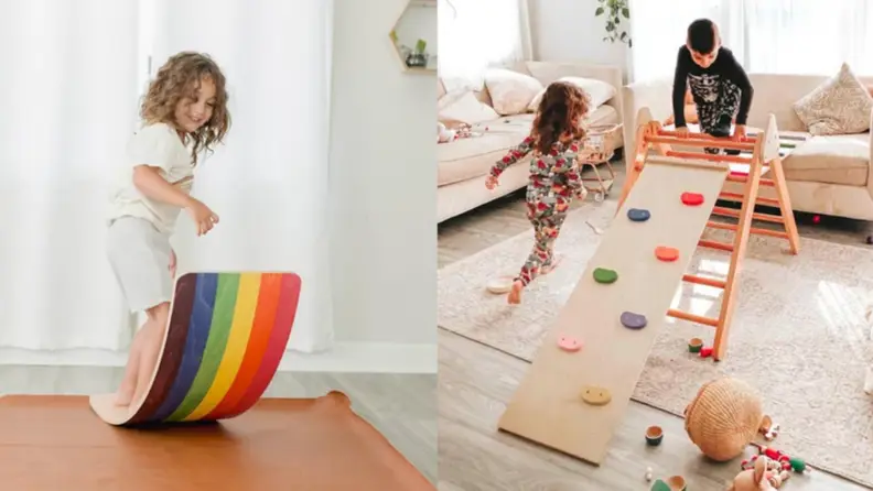 A child on a colorful wobble board and children on a play structure indoors