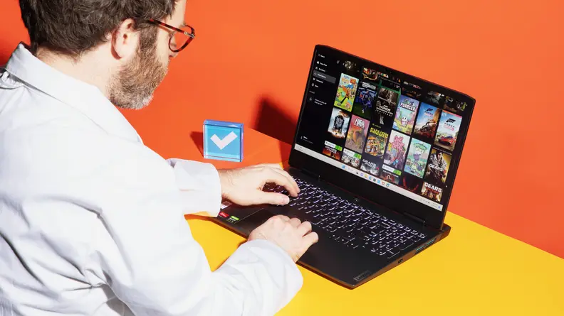 A person typing on the Lenovo IdeaPad Gaming 3 with an orange background.