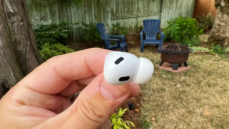 A close-up image of a hand holding a pair of Apple AirPods Pro (second gen).