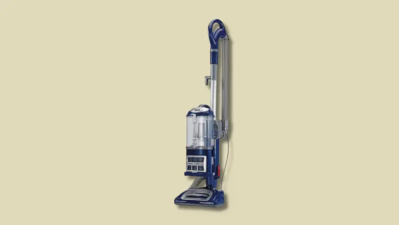 An upright vacuum cleaner on a beige background