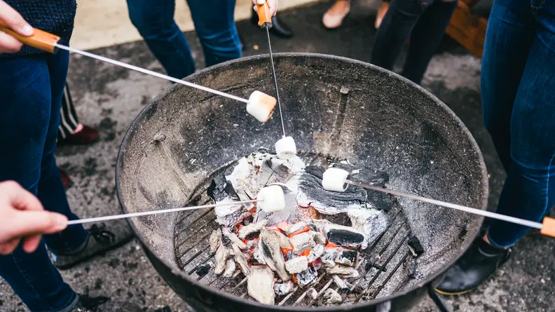 People roasting marshmallows on a grill