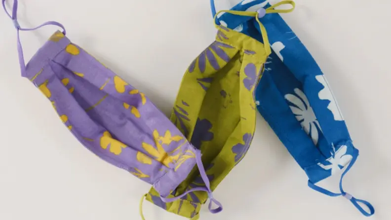Three face masks in vibrant tropical designs.