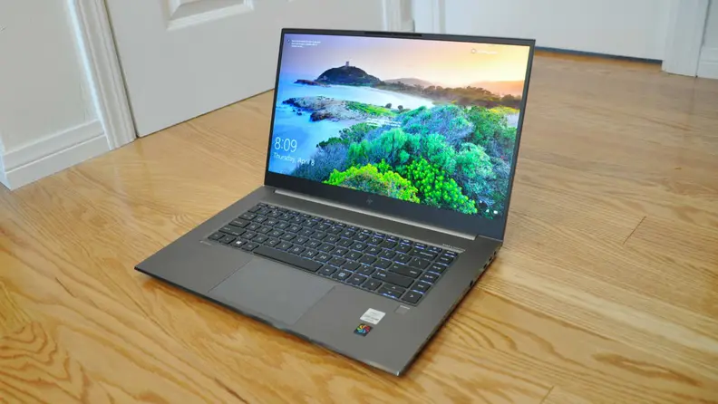 An open laptop sitting on a hardwood floor